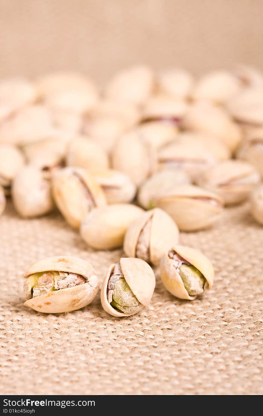 Healthy nuts pistachios on a burlap canvas shallow depth of view. Healthy nuts pistachios on a burlap canvas shallow depth of view