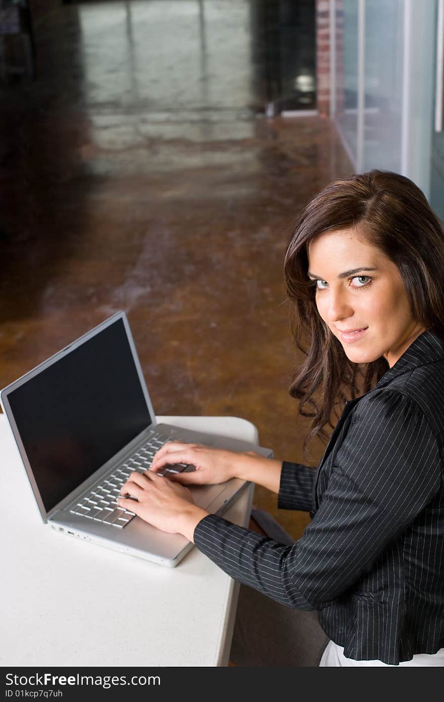 Business woman in modern office with laptop and coffee. Business woman in modern office with laptop and coffee