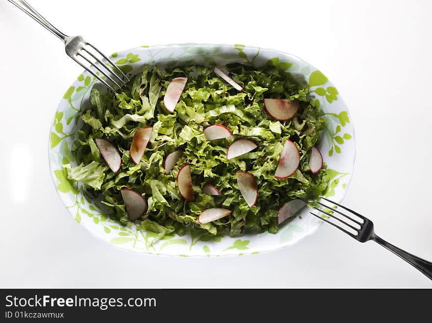 Bowl with green salad and turnip