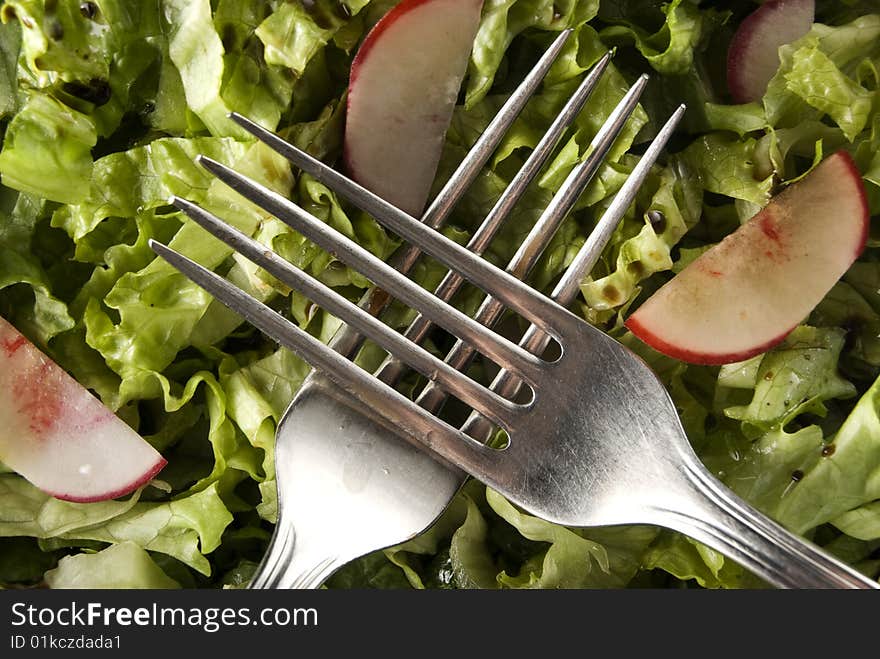 Forks on green salad with turnip