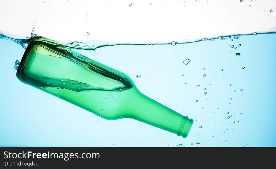 Bottle and creative splashing water.

Isolated on white