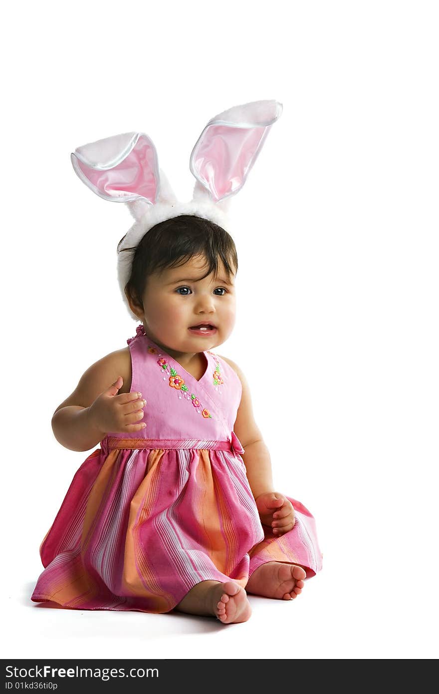 Portrait of a biracial baby girl with a pair of large bunny ears on her head. Isolated on white. Portrait of a biracial baby girl with a pair of large bunny ears on her head. Isolated on white.