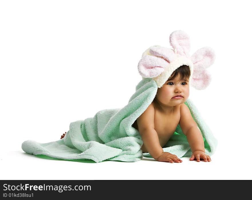 A biracial baby playing in a green towel with flower petals surrounding her head. Isolated on white. A biracial baby playing in a green towel with flower petals surrounding her head. Isolated on white.