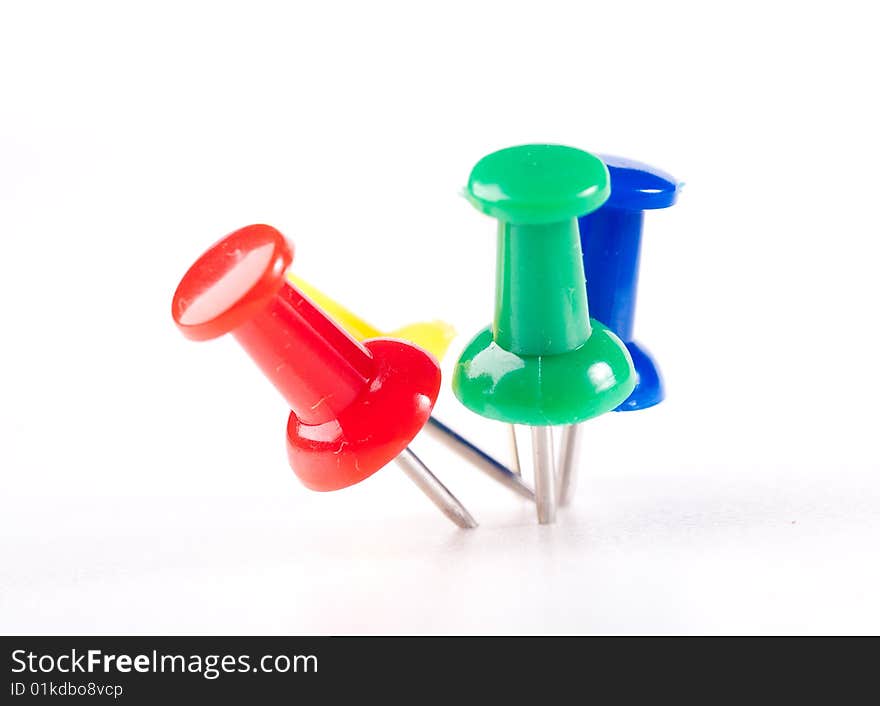 Colorful office pins isolated on white board