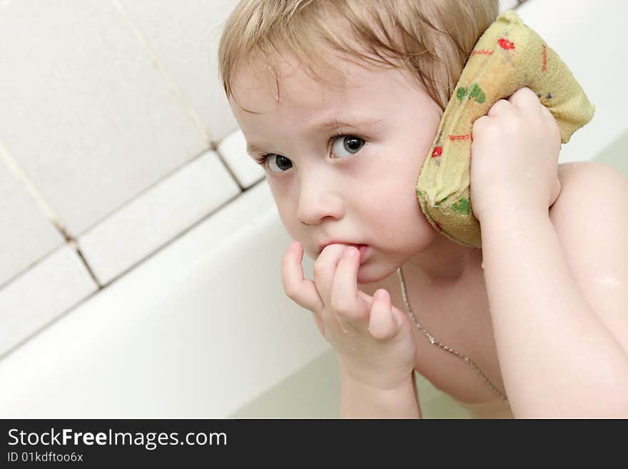 The boy washing his ear in a bathtub. The boy washing his ear in a bathtub