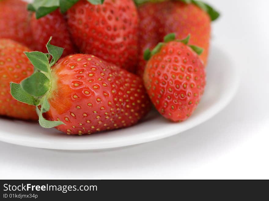 Fresh strawberry on a plate. The close-up fragment. Special focus accent.