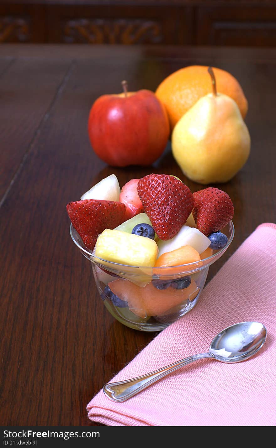 Glass cup overflowing with fresh cut up fruit. Glass cup overflowing with fresh cut up fruit