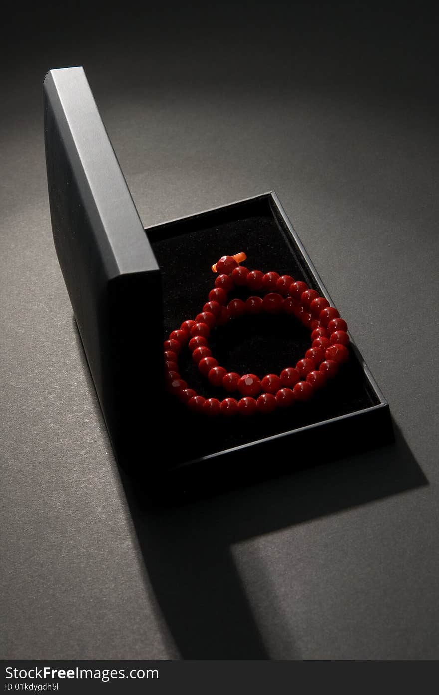 Red coral beads in a black casket