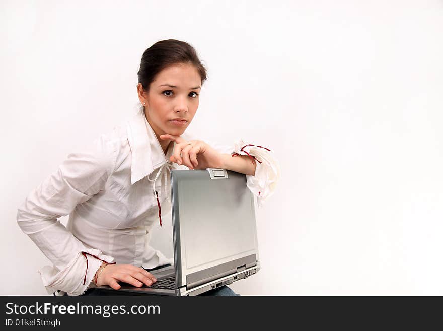 Portrait of beautiful, thoughtful,   sitting  girl in a white blouse  holding a notebook on knees, on a white background. Portrait of beautiful, thoughtful,   sitting  girl in a white blouse  holding a notebook on knees, on a white background