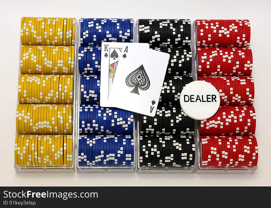 Racks of poker chips, dealer button, and cards, isolated