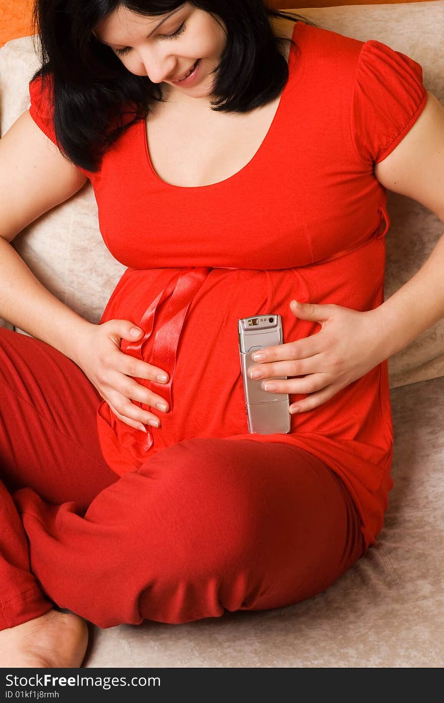 Young pregnant woman with mobile phone