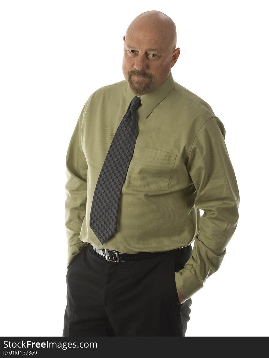 baldheaded businessman dressed in green shirt grey tie with hands in pockets of black pants. baldheaded businessman dressed in green shirt grey tie with hands in pockets of black pants