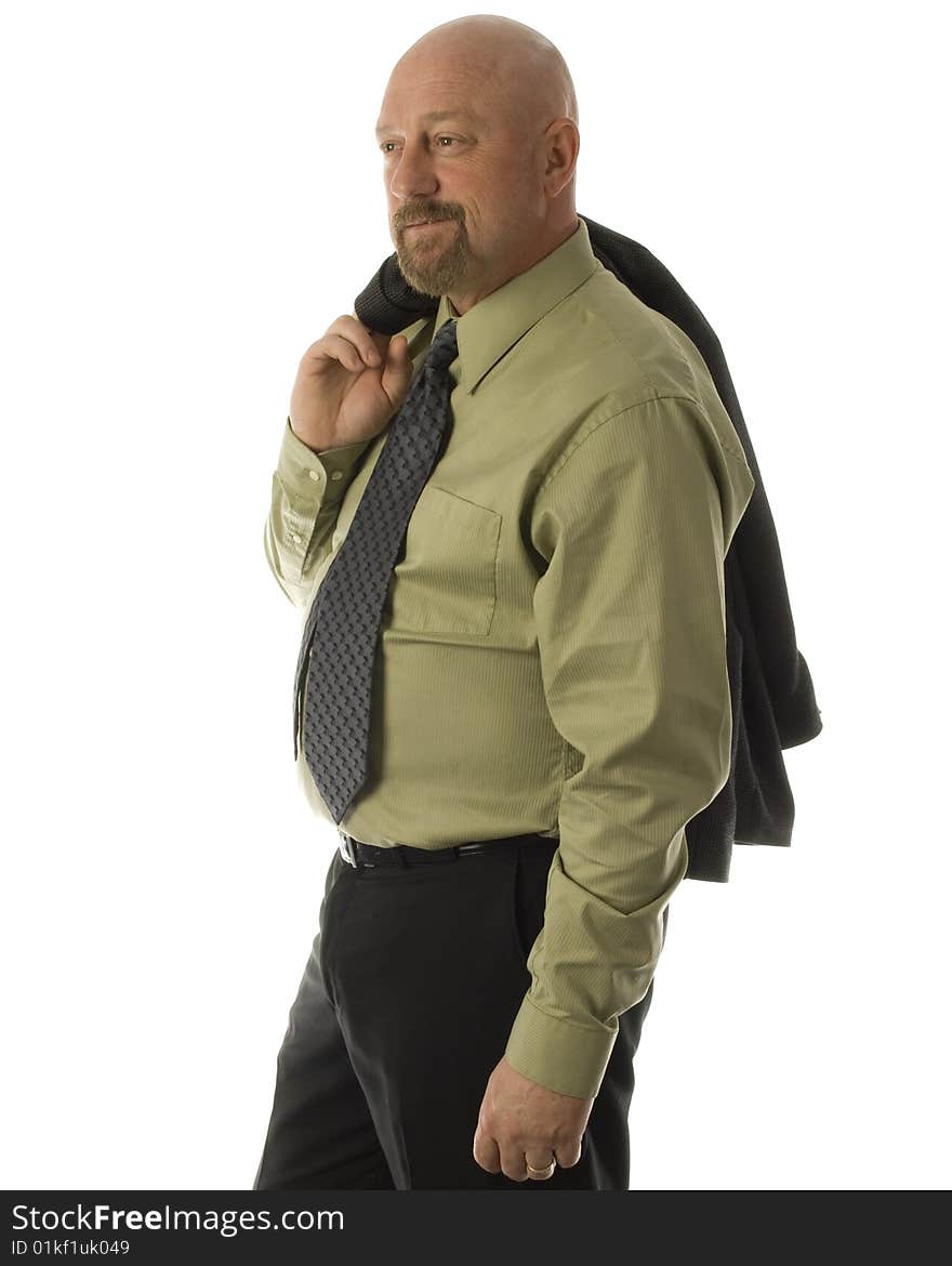 Man in dress attire with suit jacket over his shoulder wearing greenshirt and grey tie with black pants standing side ways smiling. Man in dress attire with suit jacket over his shoulder wearing greenshirt and grey tie with black pants standing side ways smiling