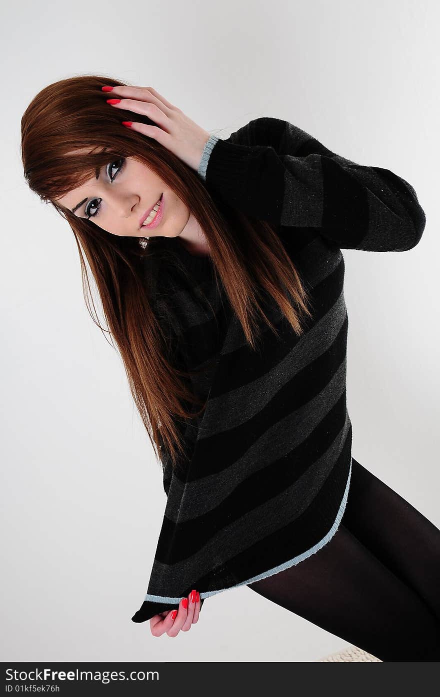 Female fashion model wearing a black stripped jumper and a pair of black leggings. Female fashion model wearing a black stripped jumper and a pair of black leggings