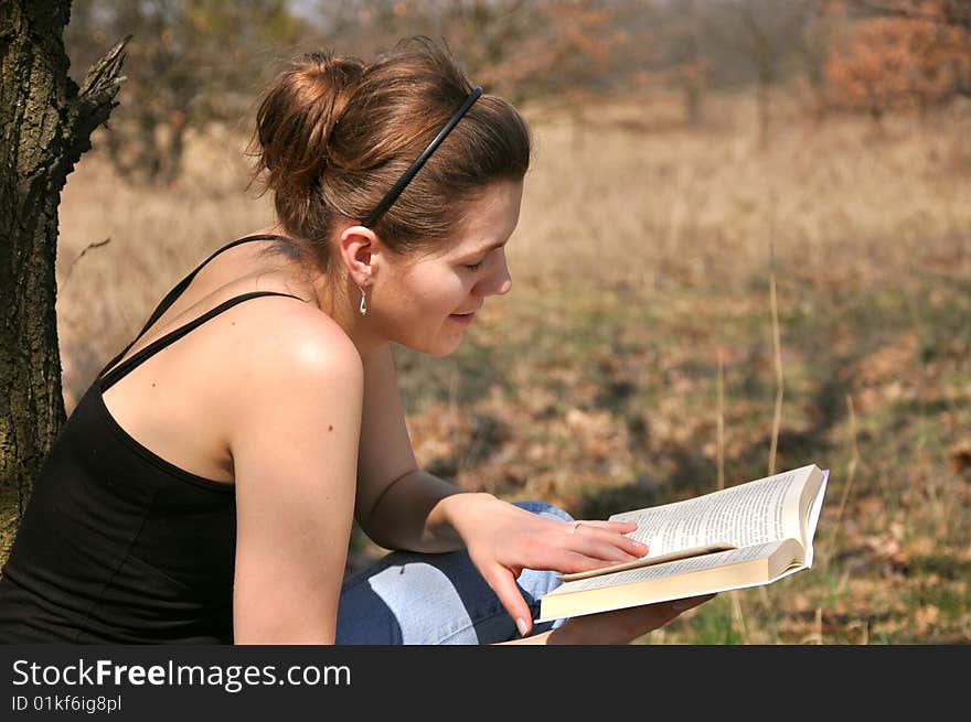 Young girl reading a book outdoor