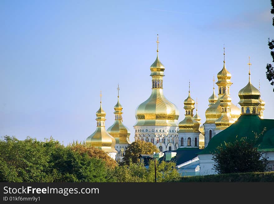 Golden church domes on blue sky background