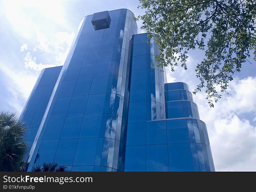 Modern blue office building vertical perspective and sky reflecting off the windows