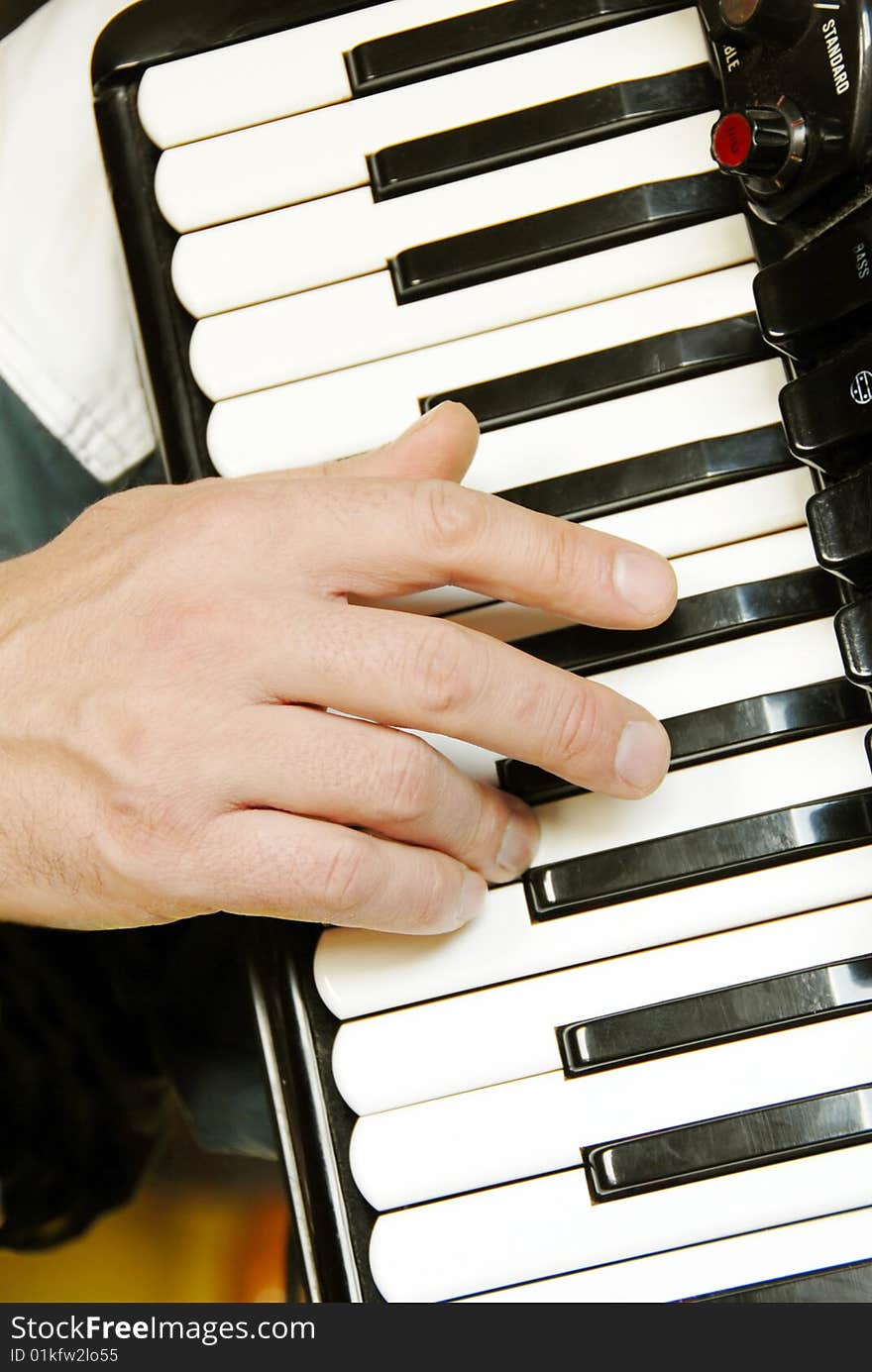 Musician hand playing accordion closeup in dramatic shadows