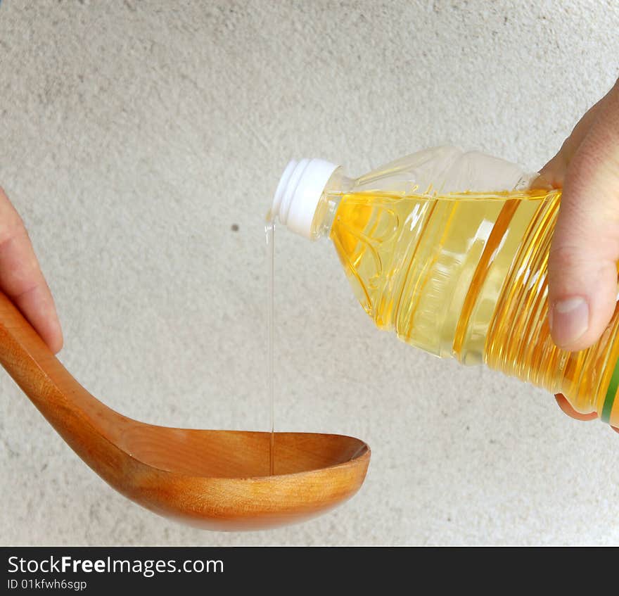 Pouring oil into wooden spoon