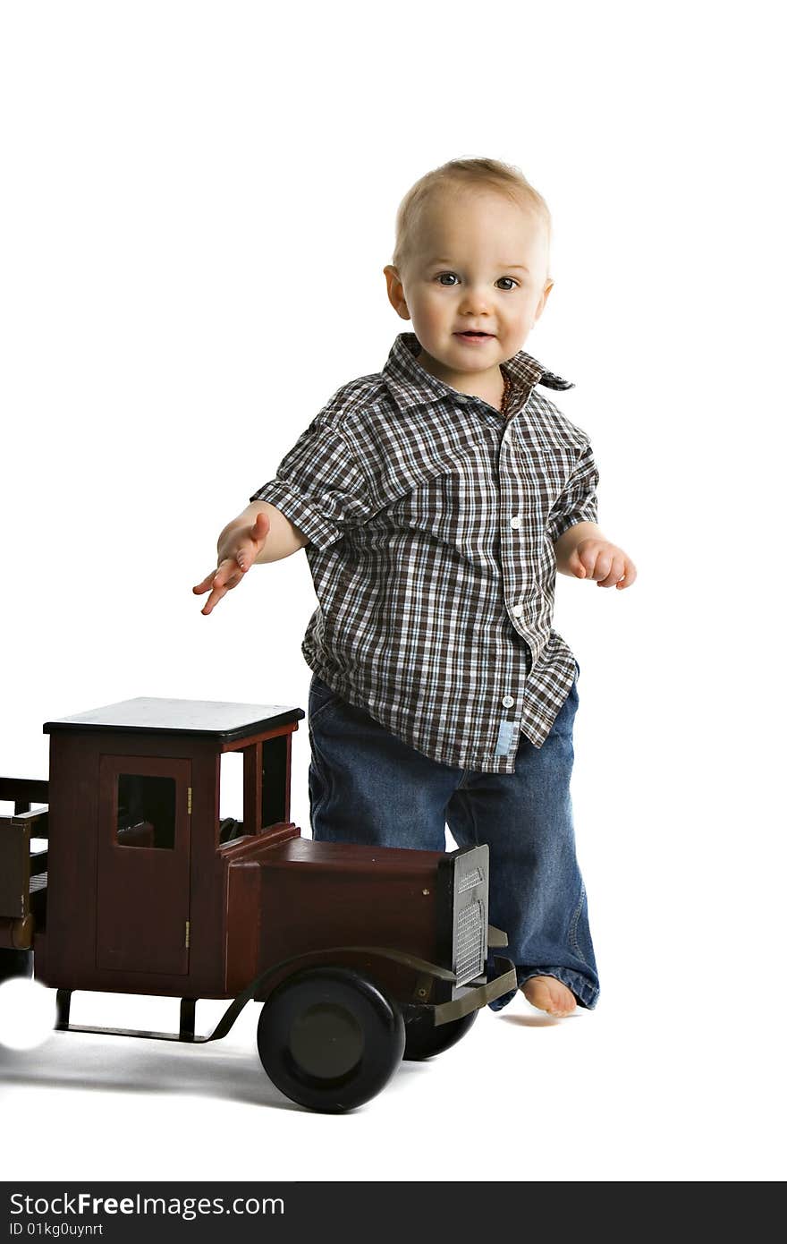 An adorable toddler boy playing with an big, wooden truck.  Isolated on white. An adorable toddler boy playing with an big, wooden truck.  Isolated on white.