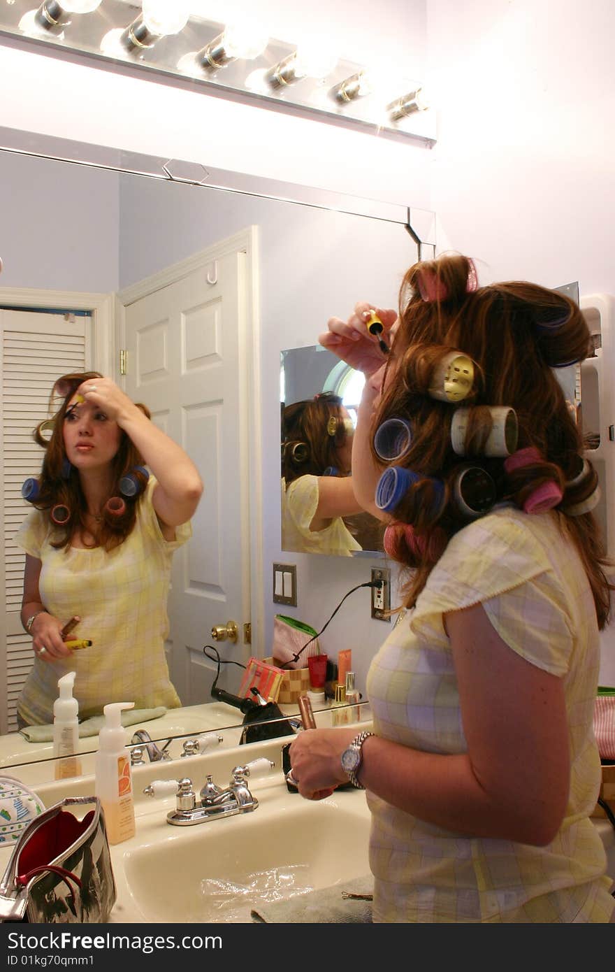 Model does her makeup in front of a mirror