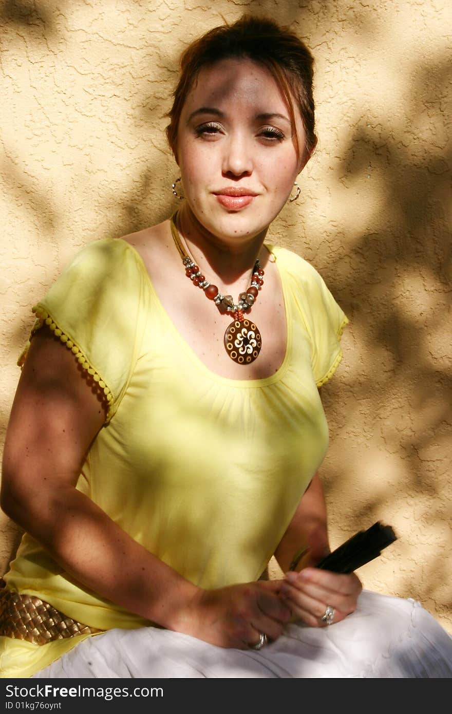 Beautiful Spanish woman with yellow blouse holds her traditional fan ready to snap you if you displease her. Beautiful Spanish woman with yellow blouse holds her traditional fan ready to snap you if you displease her.