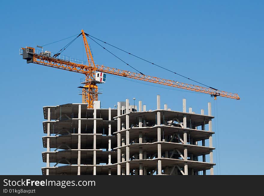 The elevating crane on clear blue sky background