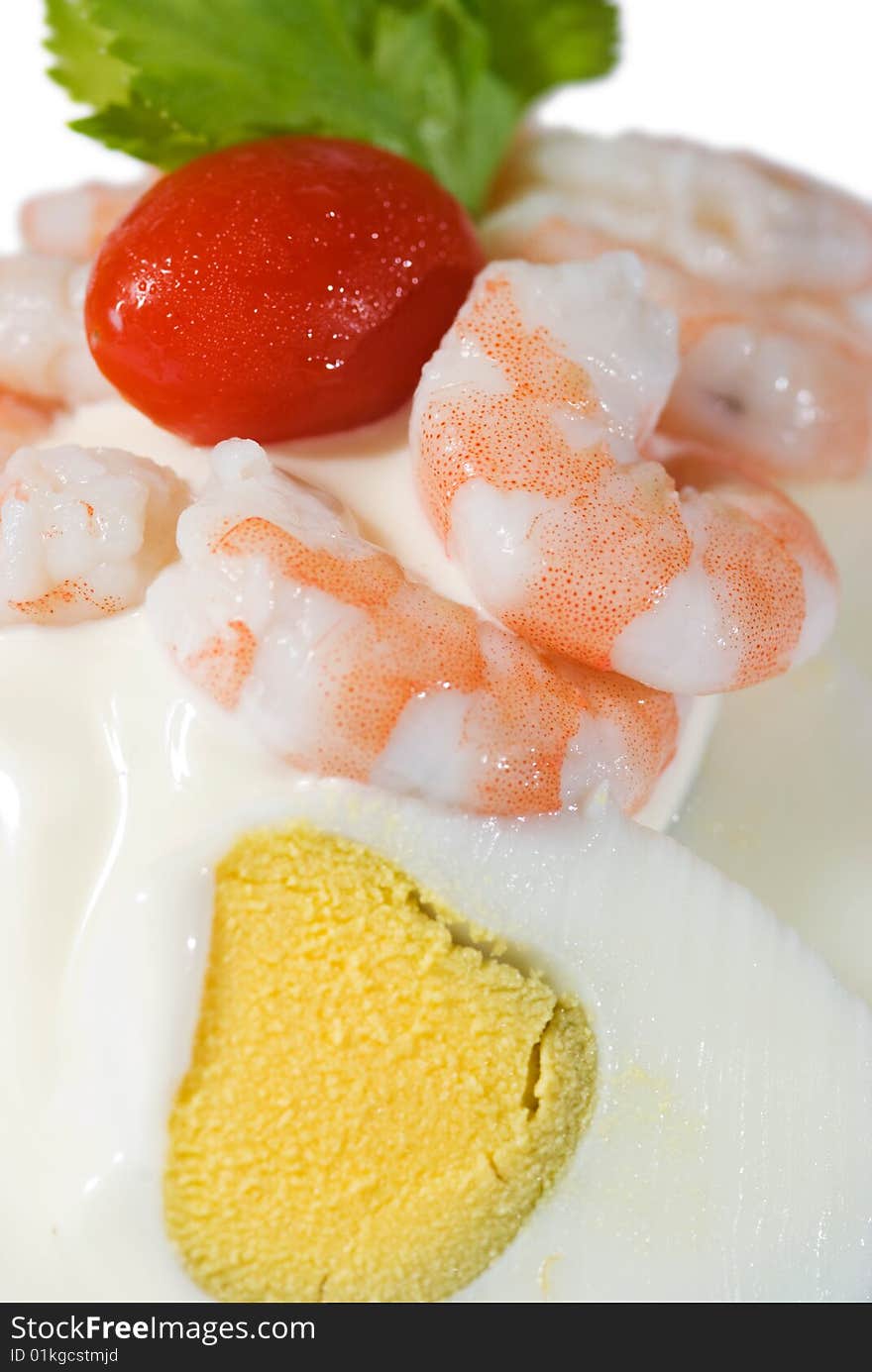 Detail of egg and shrimp sandwich with mayonnaise and a cherry tomato. Top of the photo isolated on white. Shallow depth of field with the shrimps in focus.