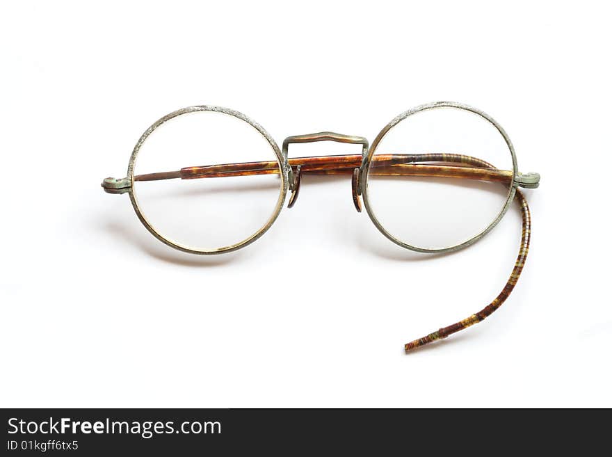 Old spectacles without one side lying on white background