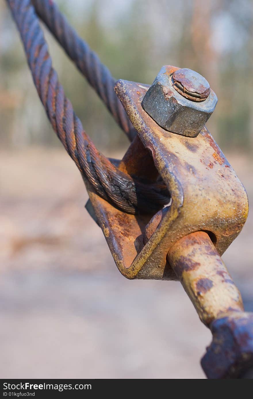 Close-up of rusting Eyelet Bolt with crimped stranded steel cable. Close-up of rusting Eyelet Bolt with crimped stranded steel cable.