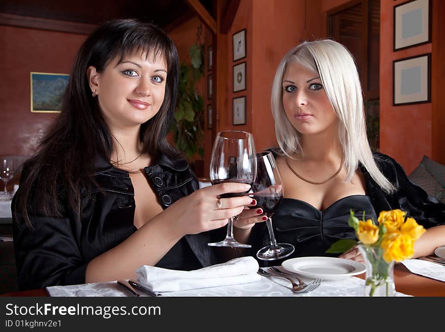 Two female friends drinking wine in the restaurant