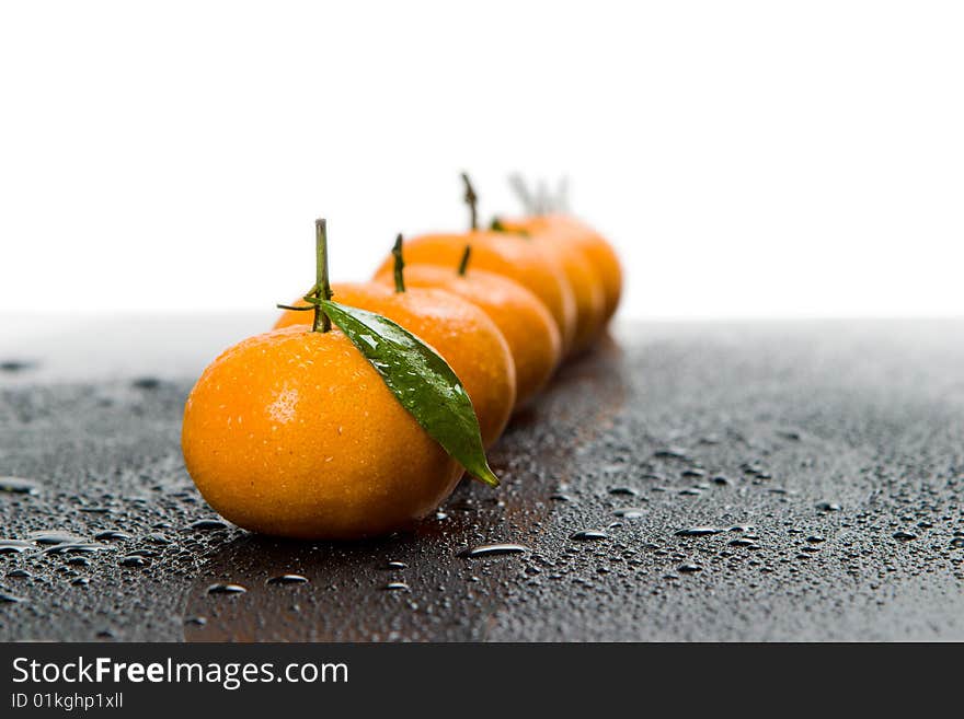 Tangerines lie in a row on the black