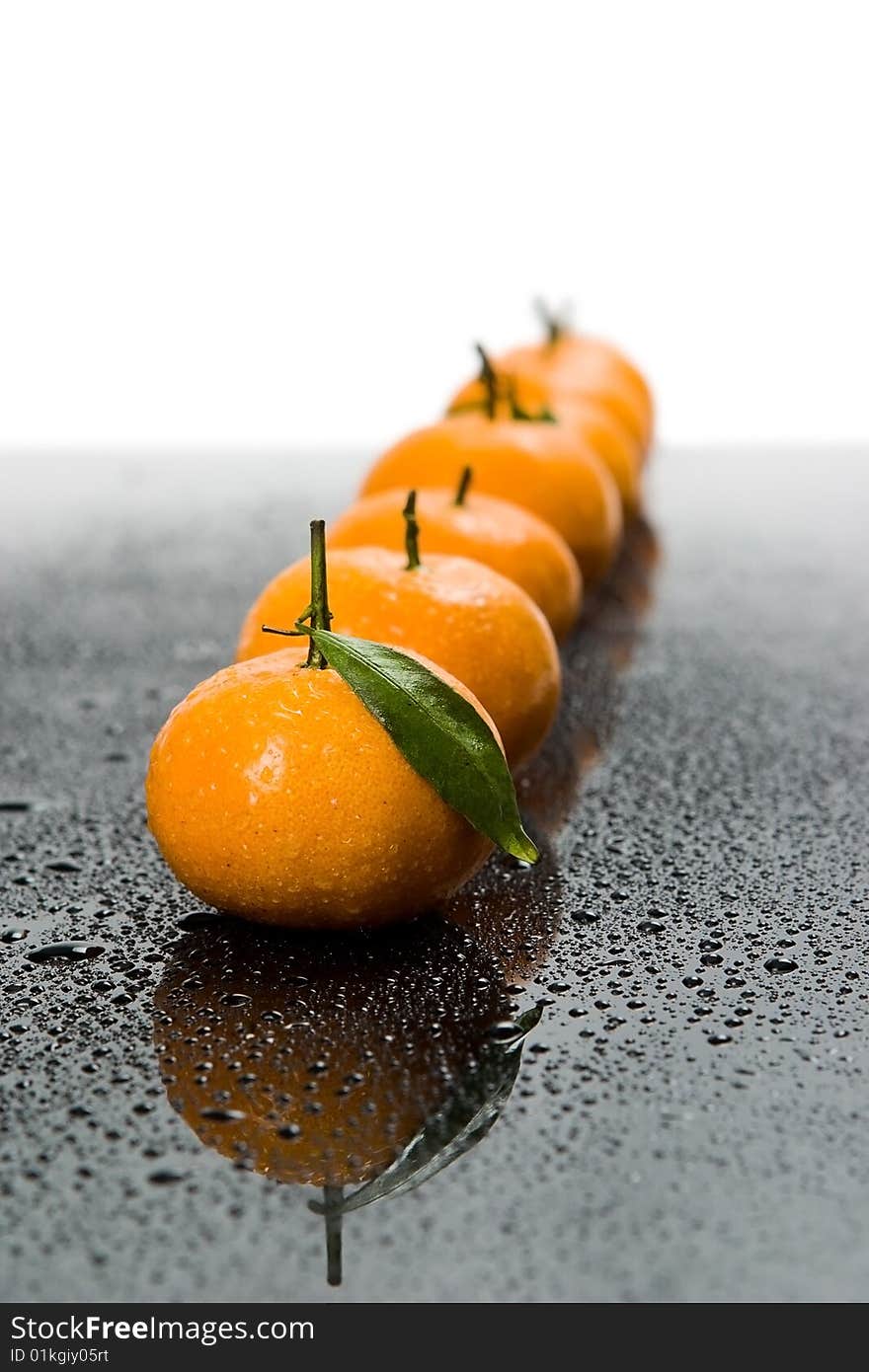 Tangerines lie in a row on the black