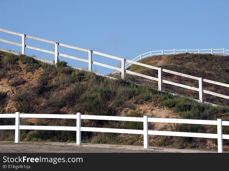 Intersecting white wooden fences on the hill side. Intersecting white wooden fences on the hill side