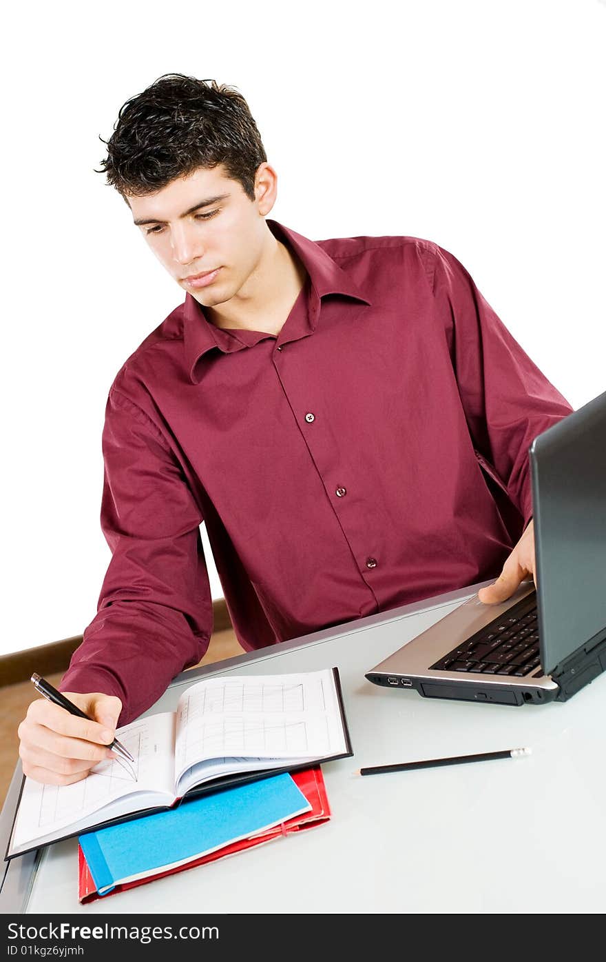 Young busy man studying and working on his laptop with note pad isolated on white background