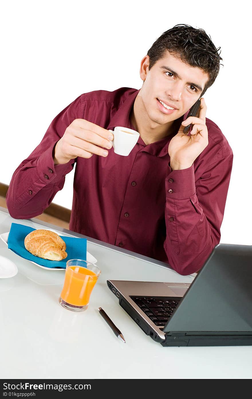 Young smiling businessman having a call on his mobile while having breakfast isolated on white background. Young smiling businessman having a call on his mobile while having breakfast isolated on white background