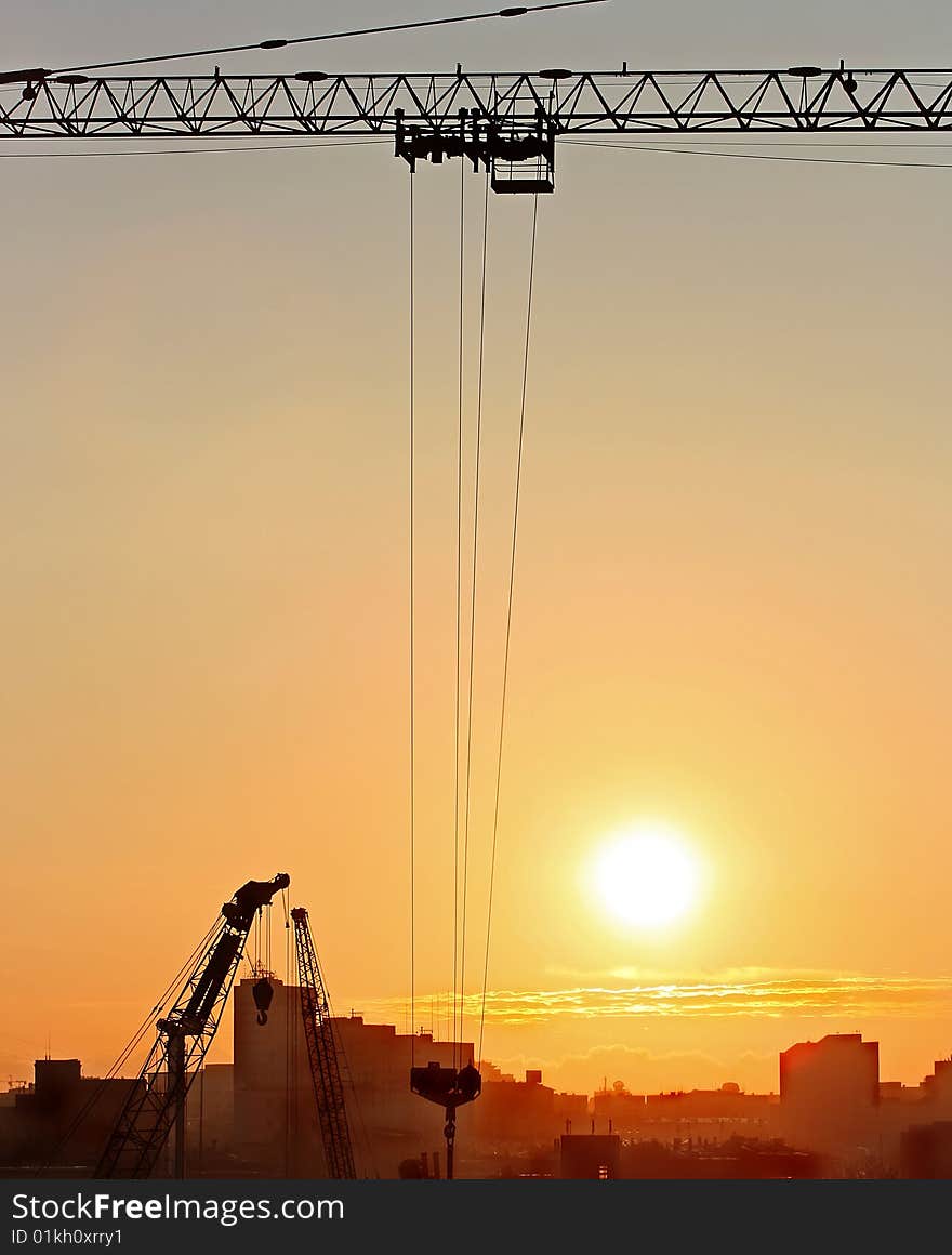 Sunrise In The City With Cranes Silhouettes