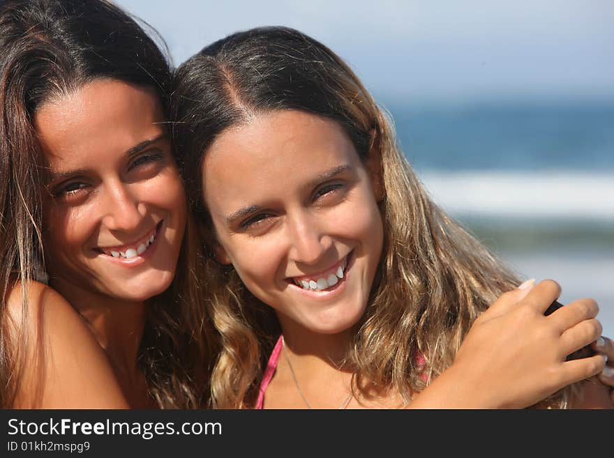 Twins smiling in the beach