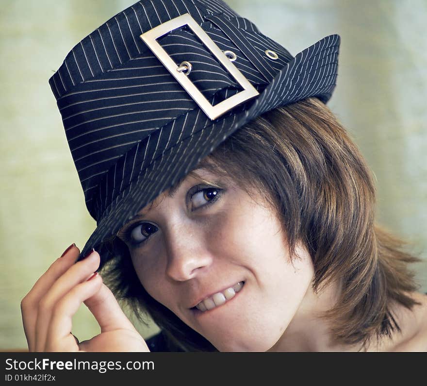 Touching her hat with her fingers, looking under the hat, facial, close-up. Touching her hat with her fingers, looking under the hat, facial, close-up