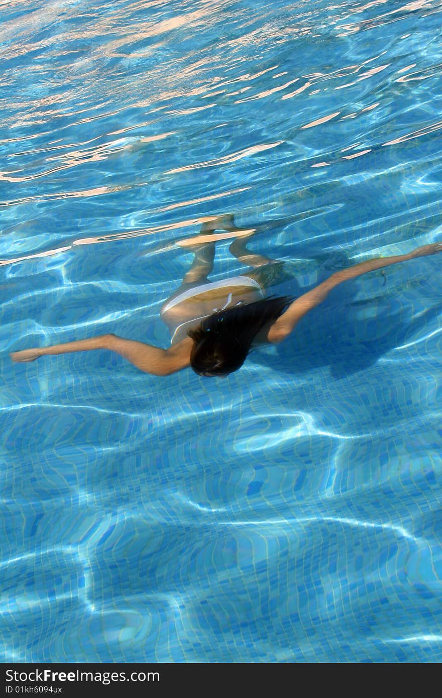 Woman in bikinis diving in the swimming pool. Woman in bikinis diving in the swimming pool