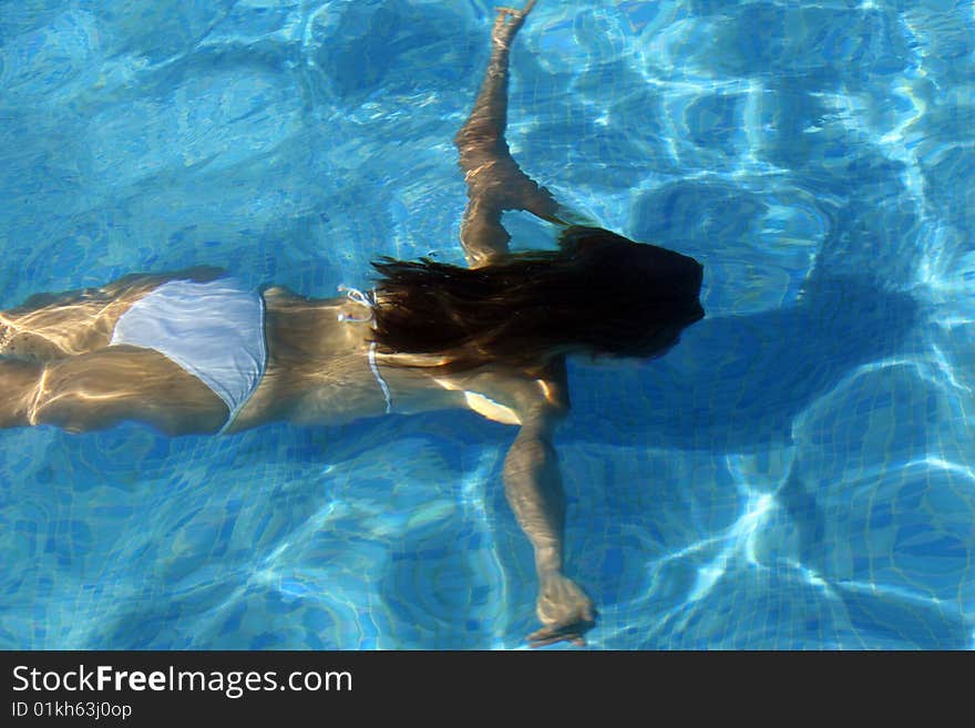 Woman in bikinis diving in the swimming pool. Woman in bikinis diving in the swimming pool