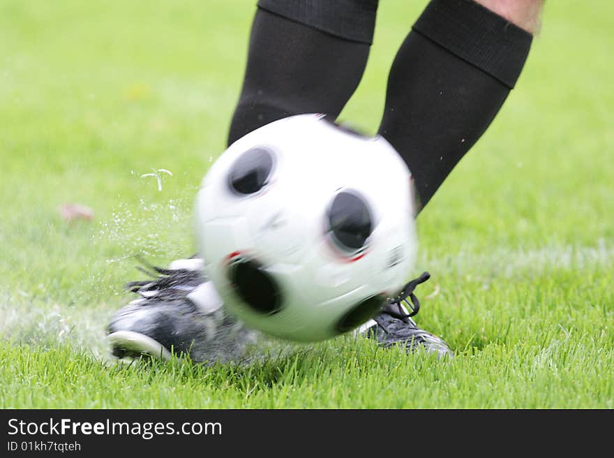 A Player is shooting a soccer ball