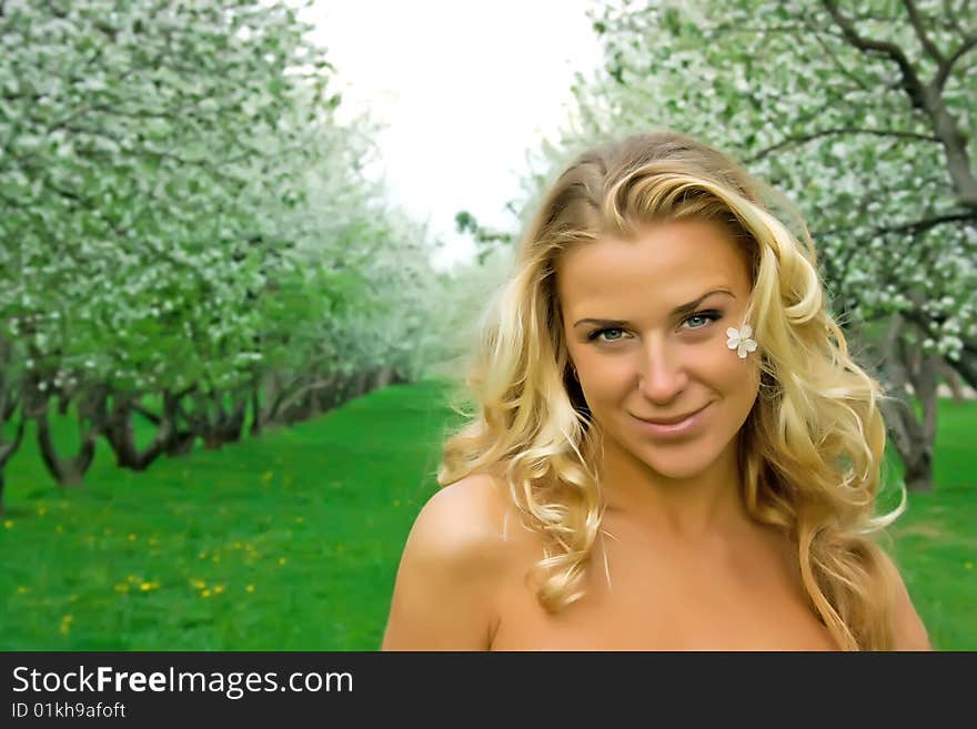 Beautiful girl with blonde hair in the cherry garden