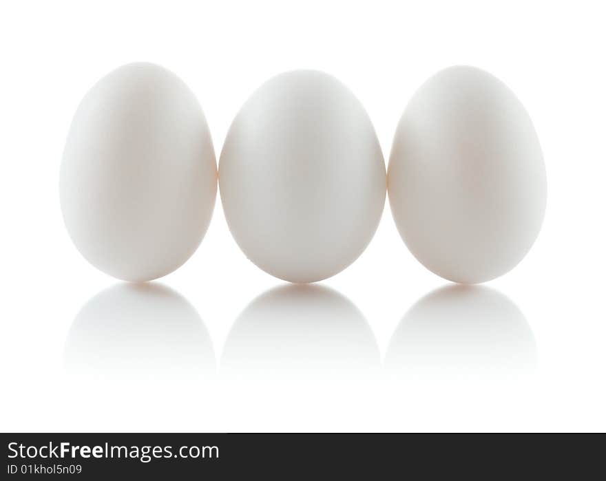 Three isolated chicken eggs in a row