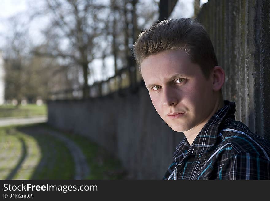 Young man is bases about the concrete wall. Young man is bases about the concrete wall