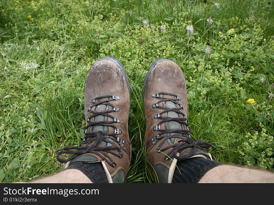 Hiking boot during rest und green lawn. Hiking boot during rest und green lawn