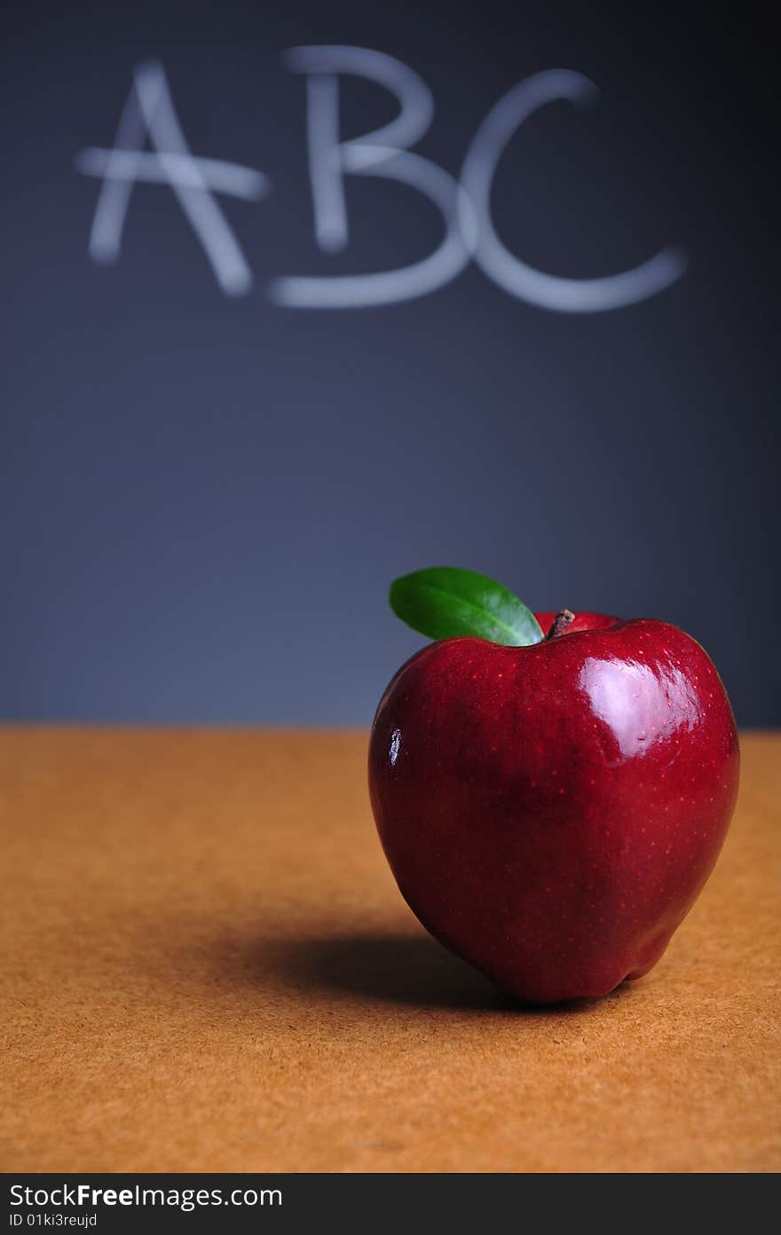 Red apple on table and blackboard with ABC letters. Red apple on table and blackboard with ABC letters