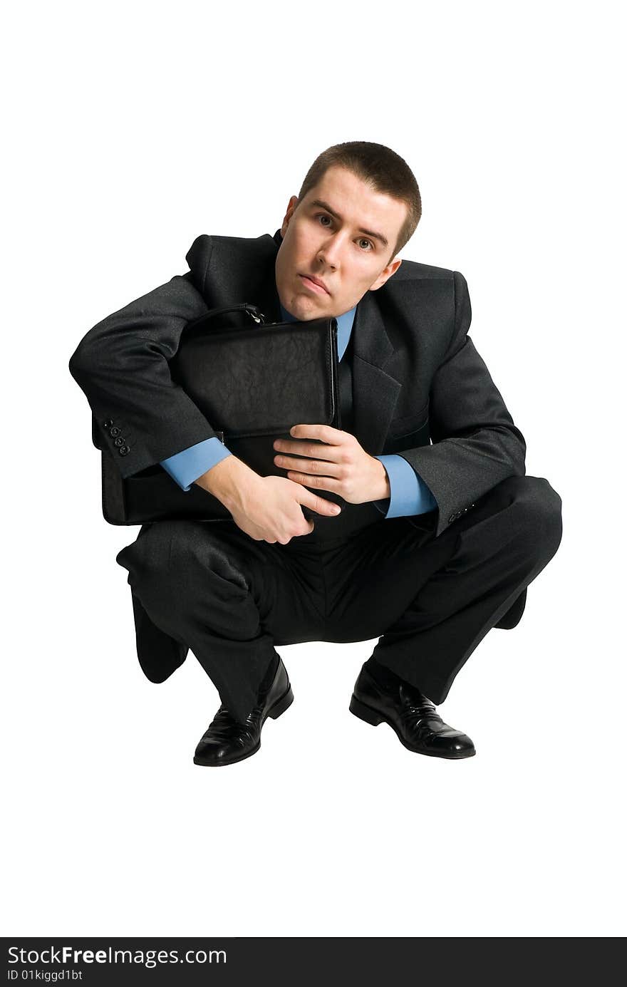 Squating businessman looking directly to the camera isolated on white