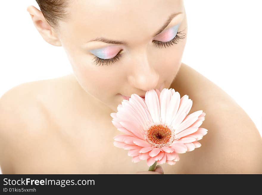 The girl smells pink gerbera on a white background