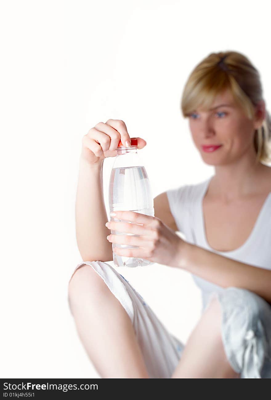 The girl of a sports kind with a bottle of water in a hand. The girl of a sports kind with a bottle of water in a hand